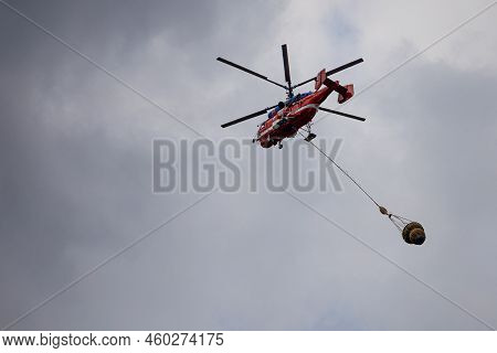Moscow, Russia - July 20, 2022: Helicopter Carries Cargo In A Hanging Basket. High Quality Photo