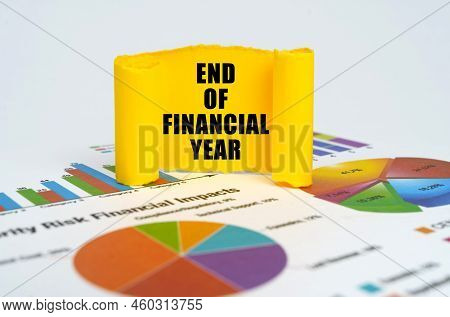 Business Concept. Against The Background Of Graphs And Charts, A Yellow Paper Plate With The Inscrip