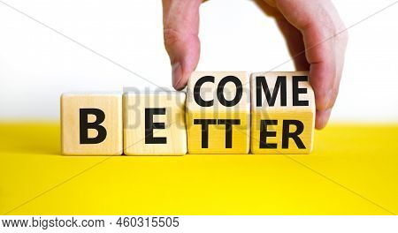 Become Better Symbol. Businessman Turns Wooden Cubes And Changes The Concept Word Better To Become. 