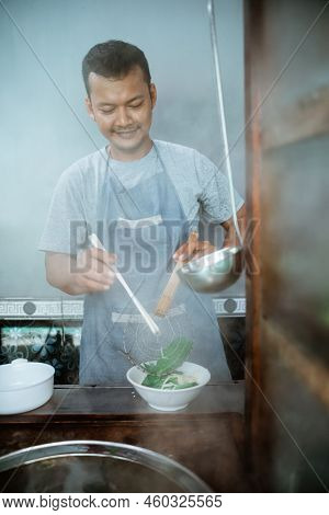 Man Seller Pouring Into The Bowl Of Boiled Noodles