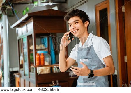 Male Seller Makes A Call Using A Mobile Phone
