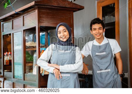 Veiled Woman And Young Man Wearing An Apron Smiling
