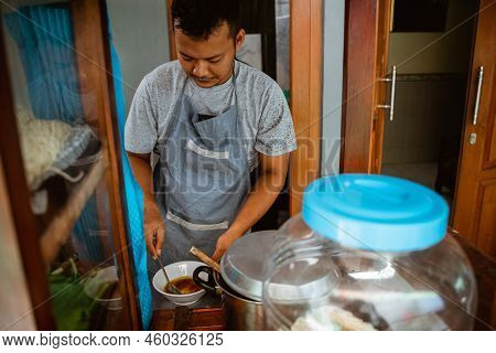 Man Seller In Apron Prepare The Seasoning In The Bowl