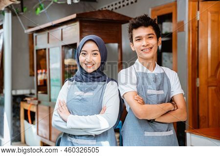 Woman In Headscarf And Young Man In Apron Smiling