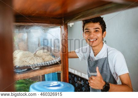 Selling Man Smiling With Thumbs Up While Taking Noodles
