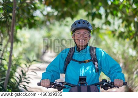 Attractive Active Senior Woman With Electrobike Standing Outdoors In The Park. Happy Elderly Woman R