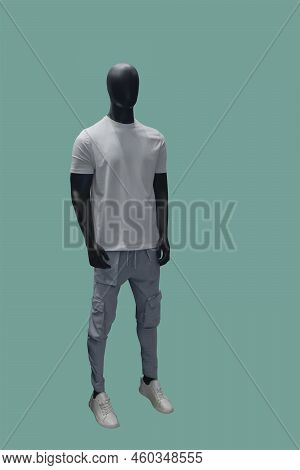 Full Length Image Of A Male Display Mannequin Wearing White T-shirt And Grey Cargo Pants Isolated On