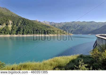 The Roselend Dam With Turquoise Water In A Mountainous Landscape In France