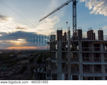 Construction Site With Cranes Against The Background Of The Evening Sky. Turret Slewing Cranes Worki