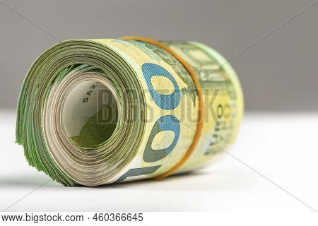 Roll Of Money. Roll Of 100 Euro Banknotes. Euro Banknotes Rolled Up On A Gray Background. The Concep