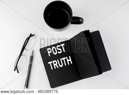 Post Truth Written Text In Small Black Notebook With Coffee , Pen And Glasess On White Background. B