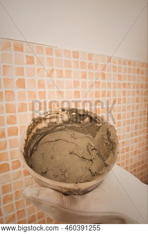 Older Man Working In Empty Apartment Repairing Holes In Walls