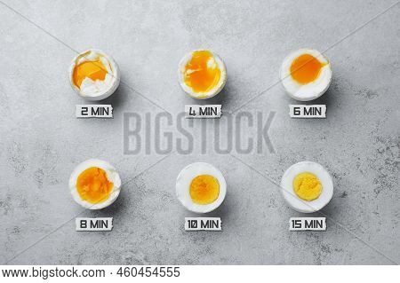 Different Readiness Stages Of Boiled Chicken Eggs On Light Grey Table, Flat Lay