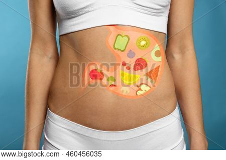 Woman With Image Of Stomach Full Of Food Drawn On Her Belly Against Light Blue Background, Closeup. 