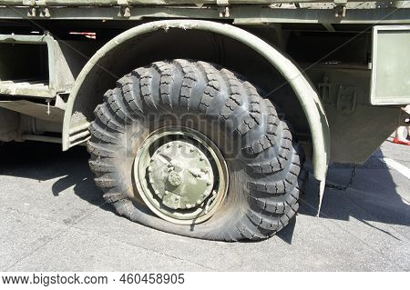 A Punctured And Flat Tire Of Military Equipment Of The Armored Personnel Carrier. Military Conflict,