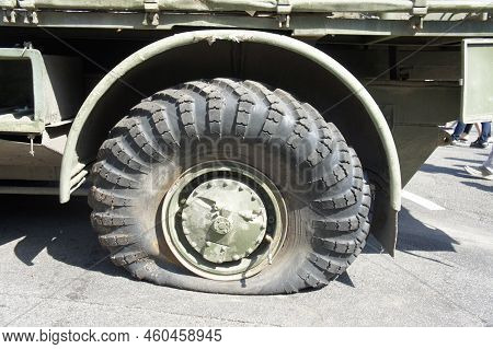 A Punctured And Flat Tire Of Military Equipment Of The Armored Personnel Carrier. Military Conflict,