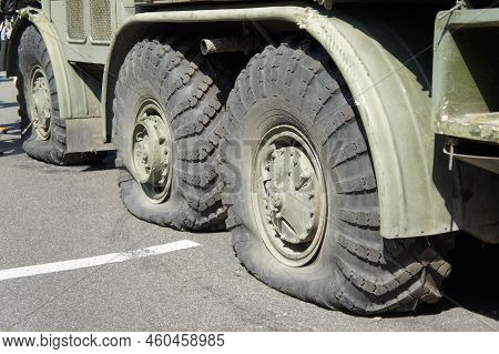 A Punctured And Flat Tire Of Military Equipment Of The Armored Personnel Carrier. Military Conflict,