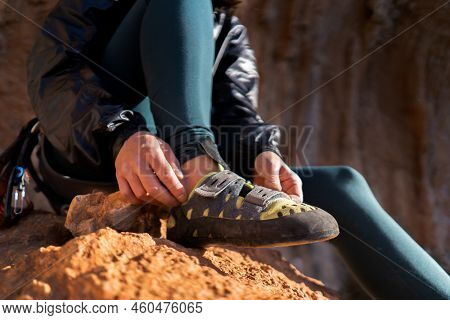 A Young Girl Puts On Special Climbing Shoes On Her Legs Before Climbing Outdoor Training, Hands And 