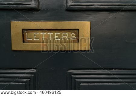 Close Up Of Dark Black Noble Wood Entrance Door With Square Mail Slot With Copper Metal Brass Inscri