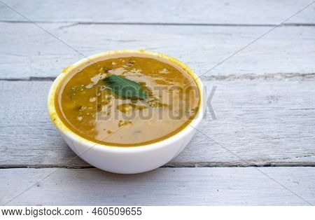 Closeup Of Ghugni Or Yellow Pea Curry In A Bowl Isolated On White Wooden Background With Copy Space