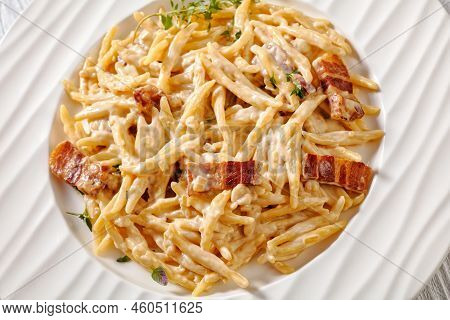 Capunti Pasta In Cream Pecorino Cheese And Pancetta Sauce On White Plate On White Wooden Table, Ital