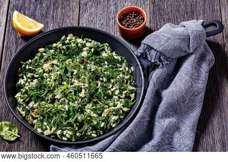 Spanakorizo, Greek Spinach And Rice Pilaf With Lemon, Dill, Spring Onion In Frying Pan On Dark Woode
