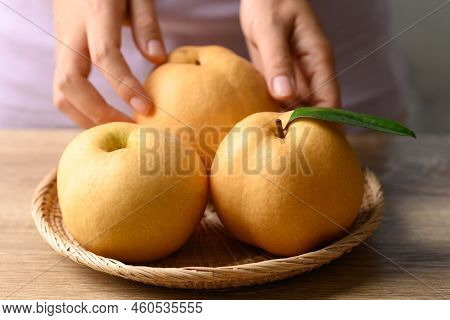 Asian Pear Or Nashi Pear In Basket With Hand On Wooden Background