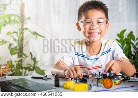 Little Child Remotely Learn Online With Car Toy Before Sent Code, Asian Kid Boy Plugging Energy And 