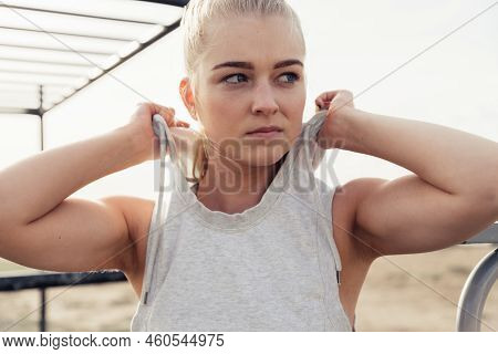 Close-up Of Serious Young Female Athlete In Sports Clothing Wearing Hood And Looking Away While Stan