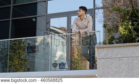 Confident Young Hispanic Business Man Standing At Railing Modern Skyscraper Office Building Looking 