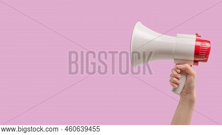 Megaphone In Woman Hands On A Purple Background.  Copy Space.