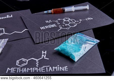 Sheets With Heroine And Methamphetamine Drug Molecules On Black Background. Syringe Filled With Hero