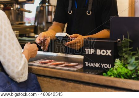 Asia Woman Use Cashless Wifi Paywave Scan On Card Reader In Coffee Shop
