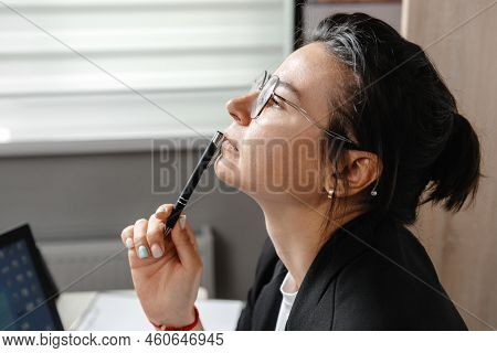 Young Attractive Woman At Desk In Office, Working With Laptop, Next To Window, Thinking About Post, 