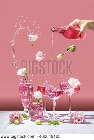 Different Elegant Champagne Glasses With Sparkling Wine, Women Hand Is Pouring Rose Wine From Bottle