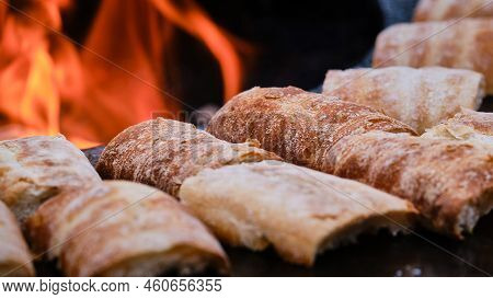 Close Up Detail View Of Sandwiches Grilled On Flat Surface Barbecue In Front Of Red Open Fire