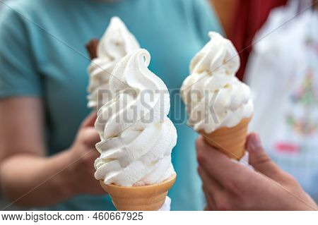 Several Soft Vanilla Ice Creams With Chocolate Sticks In Hands