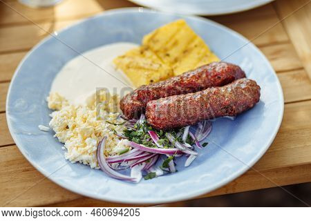 Romanian Cuisine, Traditional Sausage Called Mici Or Mititei Served With Brynza, Red Onion And Mamal