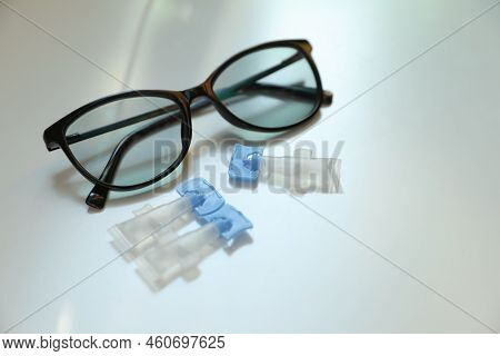 Single Dose Eye Drops And Glasses On White Table