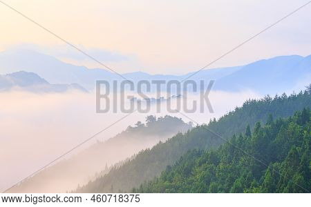 Dawn Glow On Fog And Mist In Forested Mountain Peaks Around Takeda Castle