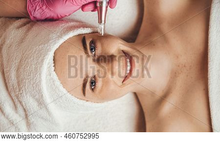 Top View Portrait Of Female Face Looking At Camera Getting Microdermabrasion Procedure In A Beauty S