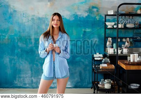 Beautiful Young Woman Drinking Morning Coffee In The Designer Kitchen At Home, Smiling, Relaxing. Co