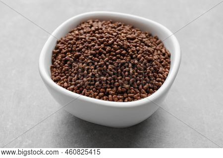 Buckwheat Tea Granules In Bowl On Light Grey Table, Closeup