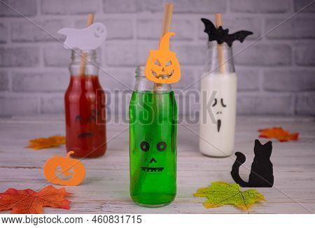 Drinks In Bottles With Monster Faces. Jack-o-lantern Face On Glass. Halloween Drinks.