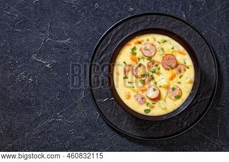 Kartoffelsuppe, German Potato Soup With Sausages, Bratwurst In Black Bowl On Dark Concrete Table, Ho
