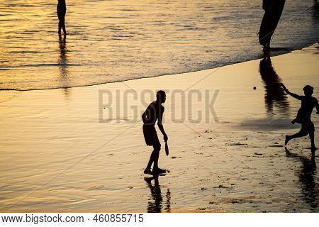 Young People Playing Frescoboll Against Sunset At Beach