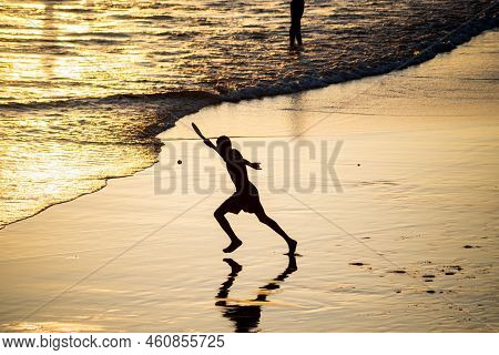 Young People Playing Frescoboll Against Sunset At Beach