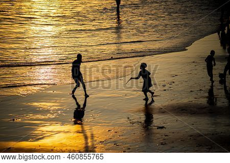 Young People Playing Frescoboll Against Sunset At Beach