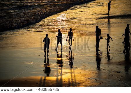People Walking E Se Divertindo On The Sand Of Beach In The Late Afternoon.