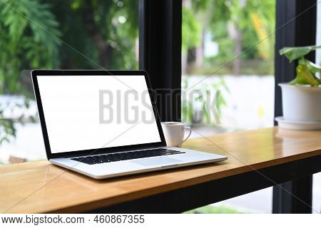 Computer Laptop With Lank Display And Cup Of Coffee On Wooden Table.